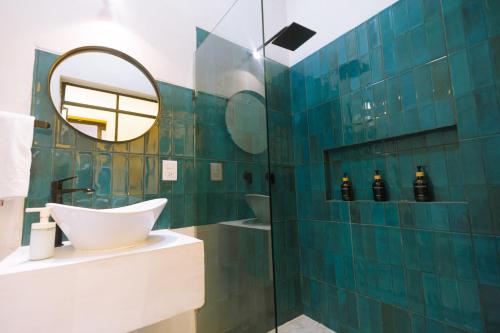 a blue tiled bathroom with a sink and a mirror at Reforma 516 in Oaxaca City