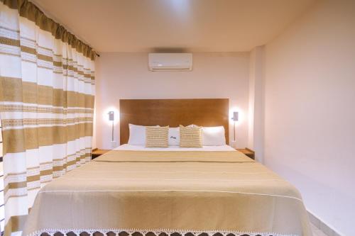 a bedroom with a large bed with two pillows at Reforma 516 in Oaxaca City