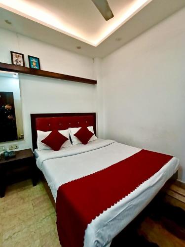 a bedroom with a large bed with red and white sheets at Hotel Parth Palace in New Delhi
