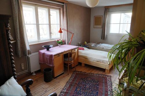 a bedroom with a desk and a bed and a window at Pension Pichelsdorf in Berlin