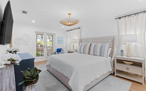 a white bedroom with a bed and a desk at Three Sisters Bungalow in Santa Rosa Beach