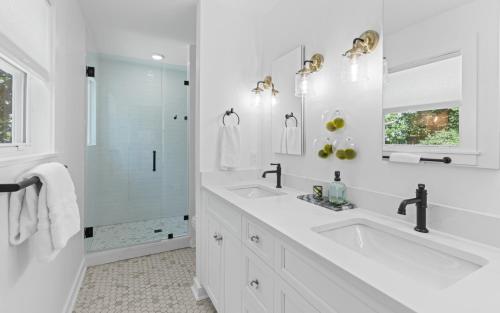 a white bathroom with two sinks and a shower at Three Sisters Bungalow in Santa Rosa Beach