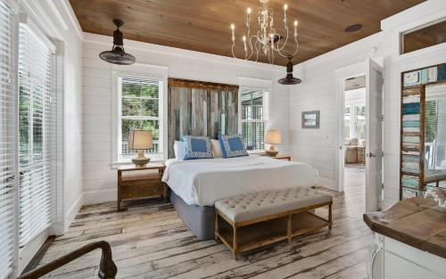 a white bedroom with a bed and a chandelier at Watercolor Reunions in Santa Rosa Beach