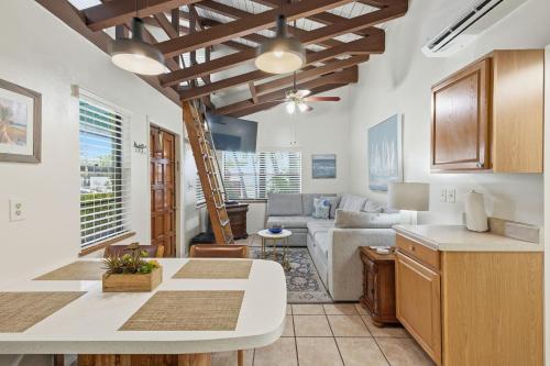 a kitchen and living room with white walls and wooden ceilings at Sand Dune Shores in Palm Beach Shores