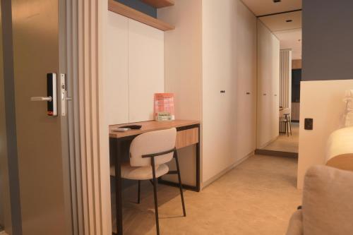 a room with a desk with a chair and a bedroom at Xtay Oslo Florianópolis - Residential studio 5 minutes from downtown, close to Epic School and Atlantis Executive Center in Florianópolis