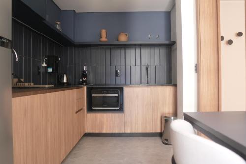 a kitchen with wooden cabinets and a microwave at Xtay Oslo Florianópolis - Residential studio 5 minutes from downtown, close to Epic School and Atlantis Executive Center in Florianópolis