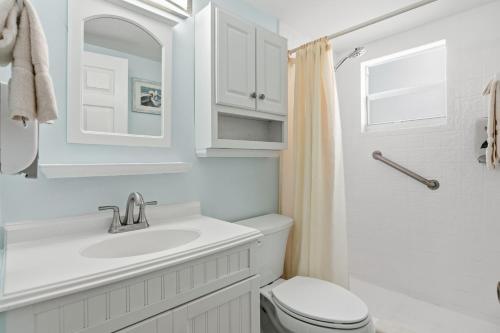 a white bathroom with a sink and a toilet at Sand Dune Shores in Palm Beach Shores