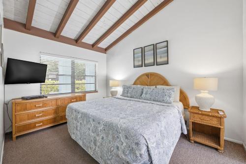a bedroom with a bed and a flat screen tv at Sand Dune Shores in Palm Beach Shores
