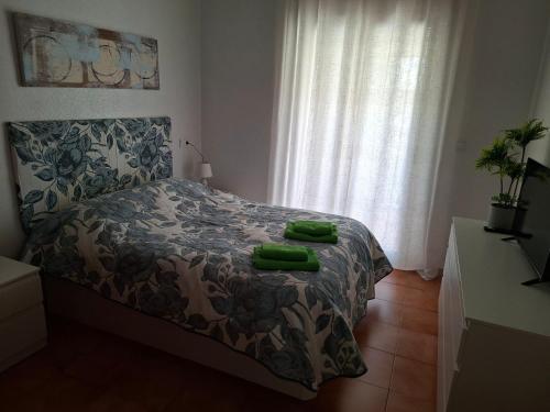 a bedroom with a bed with two green objects on it at Casas Holiday - Playa la Mata Laredo in La Mata
