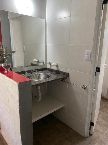 a bathroom with a sink and a mirror at LA TORRE - Complejo de cabañas in Villa Rumipal