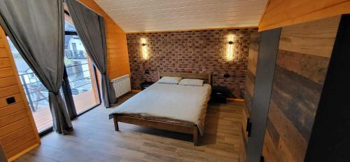 a bedroom with a bed and a brick wall at Barnhous in Mykulychyn