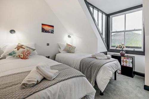 two beds in a white room with a window at 2 Bed in St. Ives oc-r28154 in St Ives