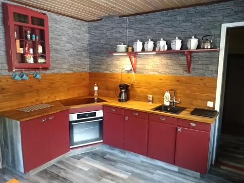 a kitchen with red cabinets and a sink at Urlaub im Elchland in Letafors