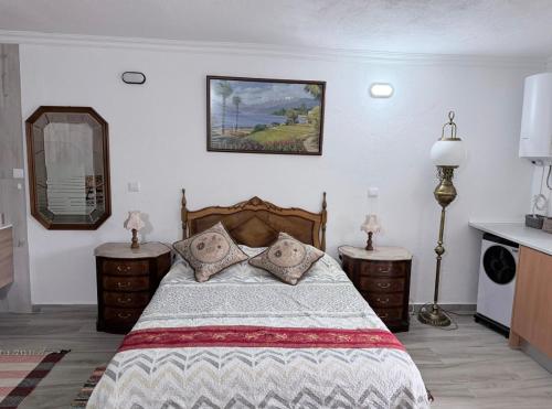 a bedroom with a bed with two dressers and a mirror at Zion Jardim Monsanto in Monsanto