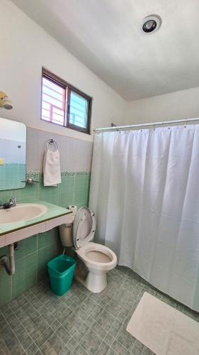 a bathroom with a toilet and a sink at Hotel Monserrat in Mérida