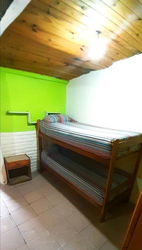 a room with a bed with a green wall at Dpto en Santa María de Punilla in Córdoba