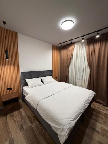 Un dormitorio con una gran cama blanca y una ventana. en Codex Kolasin, en Kolašin