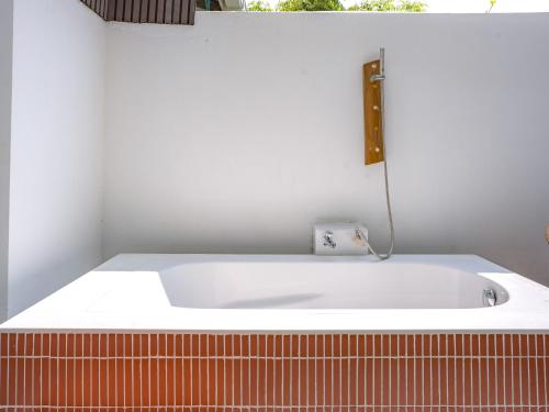 a white bath tub sitting in a room at Thundi by Biosphere in Maalhos