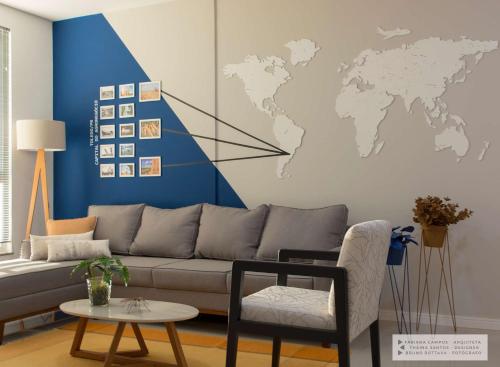 a living room with a couch and a world map on the wall at Apartamento Geomundi proximo do lago e Shopping in Toledo