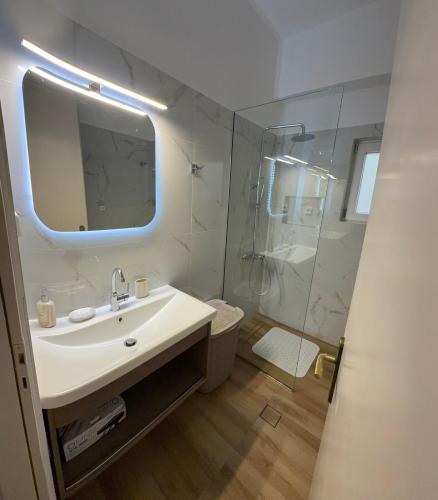 a white bathroom with a sink and a shower at Apartments Kalaitzakis with private pool in Sitia