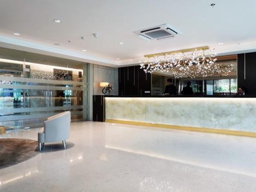 a hotel lobby with a bar and a chair at Cinnamon Life Residency in Colombo