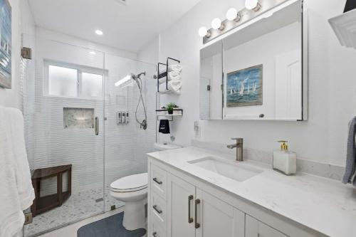a white bathroom with a sink and a toilet at Private 3BR Home - Hot Tub, Yard, Arcade & Parking in Simi Valley