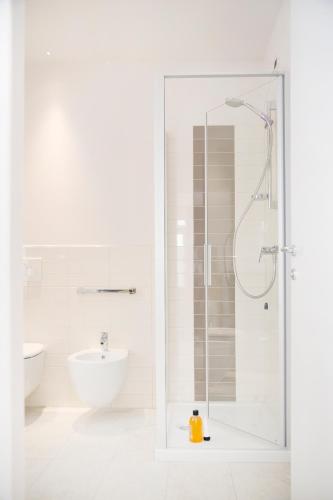 a white bathroom with a shower and a sink at Domus Residence in Domodossola