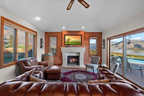 a living room with a leather couch and a fireplace at Three Lakes Haven - Pacific Retreats in Manson