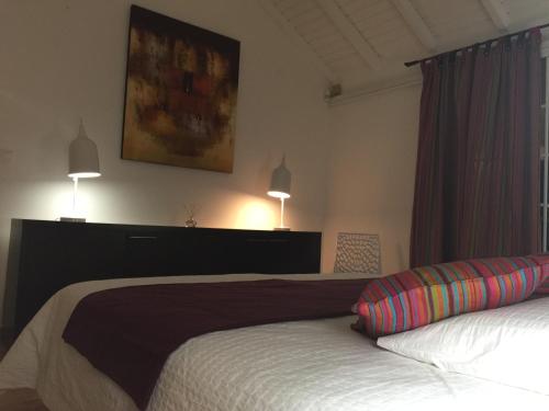 1 dormitorio con 2 camas y 2 lámparas en la pared en Villa Vue Océan, en Le Moule