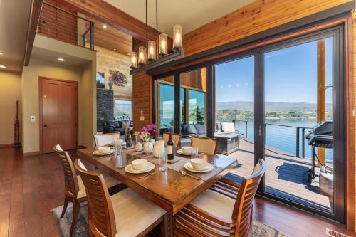 a dining room with a table and chairs and a balcony at Constellations Lake House at Chelan - Pacific Retreats in Chelan