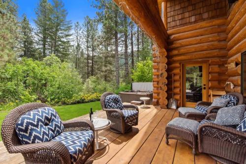 a porch of a log cabin with chairs and a grill at Big Jim Mountain Lodge - Pacific Retreats in Leavenworth