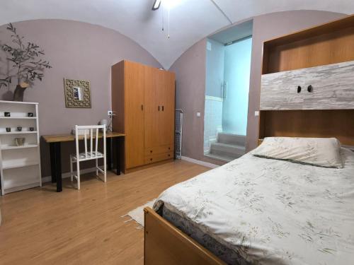 a bedroom with a bed and a desk and a chair at Apartamento El Olivar de Cáceres in Cáceres