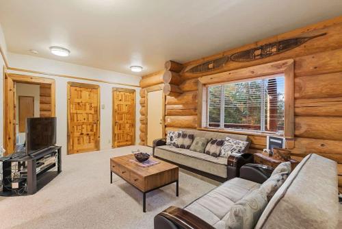 a living room with a couch and a tv at Bear Ridge Cabin - Pacific Retreats in Leavenworth