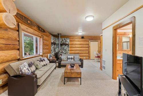 a living room with a couch and a tv at Bear Ridge Cabin - Pacific Retreats in Leavenworth