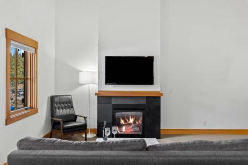 a living room with a fireplace with a television above it at Valhalla - Pacific Retreats in Leavenworth