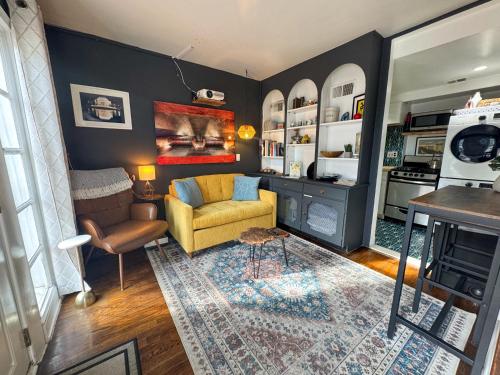 a living room with a yellow chair and a couch at Capitol Hill Carriage House in Washington, D.C.