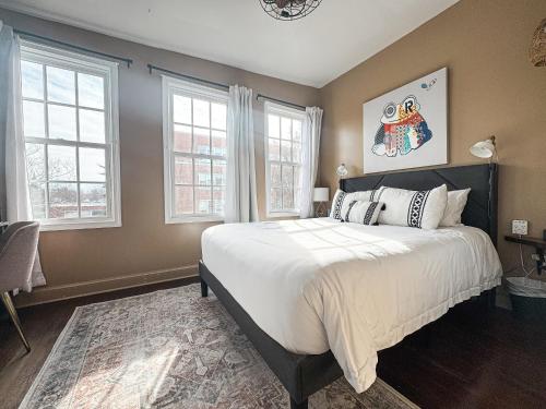 a bedroom with a large bed and two windows at Capitol Hill Carriage House in Washington, D.C.