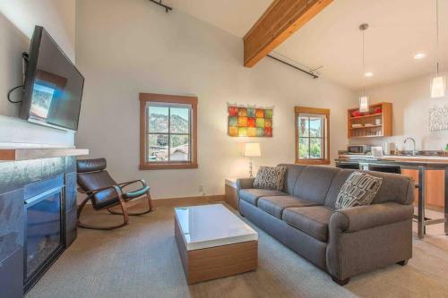 a living room with a couch and a tv at Annapurna - Alice Lodging in Leavenworth