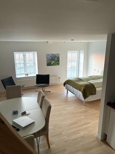 a bedroom with a bed and a table and chairs at Gammel Løgten Strandkro in Hornslet