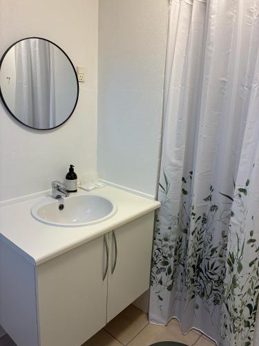 a white bathroom with a sink and a mirror at Gammel Løgten Strandkro in Hornslet