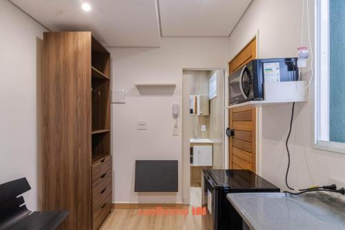a kitchen with a counter top and a tv on a wall at Apartamento no tradicional Bairro do Bixiga em SP in São Paulo