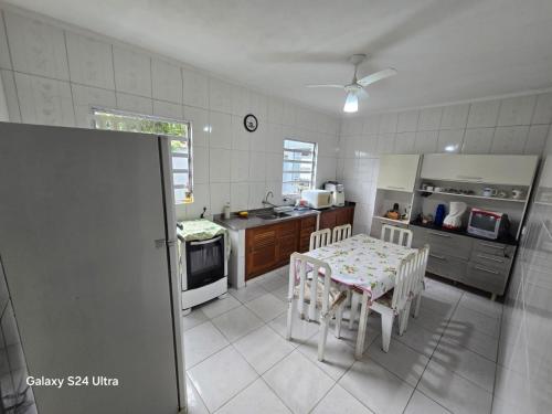 a kitchen with a table and chairs in it at Família Marques in Itanhaém