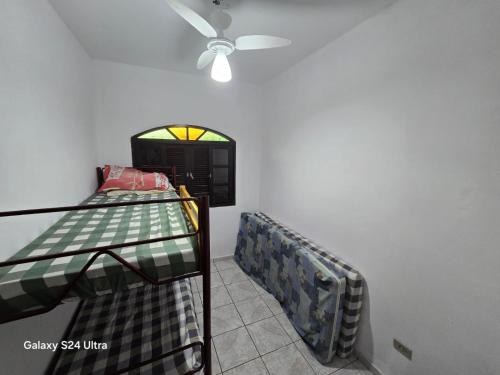 two bunk beds in a room with a ceiling fan at Família Marques in Itanhaém