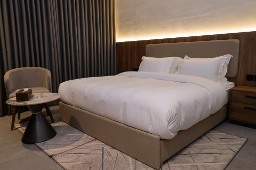 a bedroom with a large bed and a side table at لمحة للشقق المخدومة in Riyadh