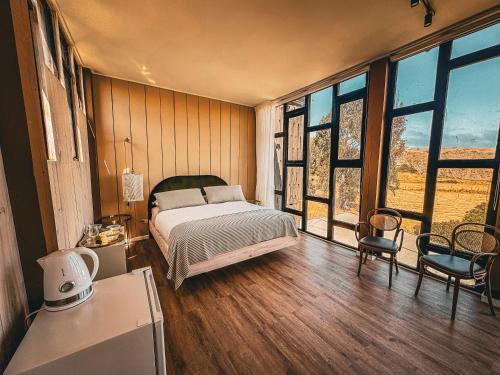 a bedroom with a bed in a room with windows at Bed & Breakfast Casa Ziré in Navidad