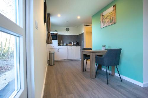 a kitchen and dining room with a table and chairs at BenB Tuskendepade in Oldeholtpade