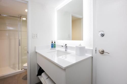 a white bathroom with a sink and a mirror at Coco Key Hotel & Water Park Resort in Orlando