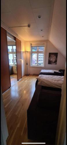 a room with two beds in a room with wooden floors at Central Stay Odda in Odda