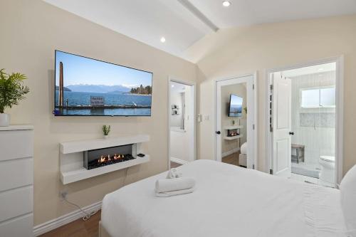 a white bedroom with a bed and a fireplace at Luxury 1BR Suite Kitchen, Fireplace, Laundry, BBQ in Simi Valley