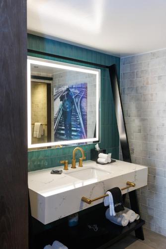a bathroom with a sink and a mirror at Bally's Baton Rouge Hotel in Baton Rouge